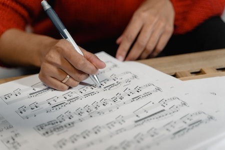 A Person Writing on a Sheet Music - things you can do with chatgpt