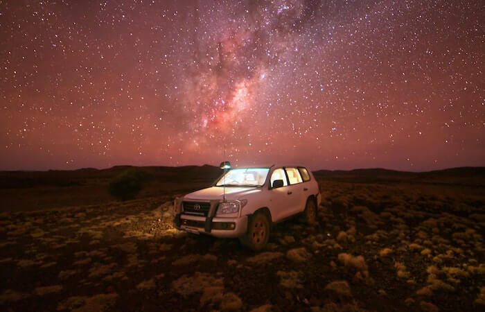 White Suv on Brown Field Under Starry Night - difference between all wheel drive and 4 wheel drive