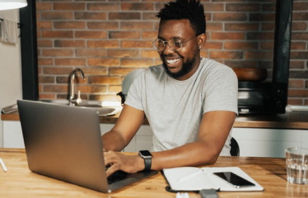 Man smiling at laptop - affordable tax service near me
