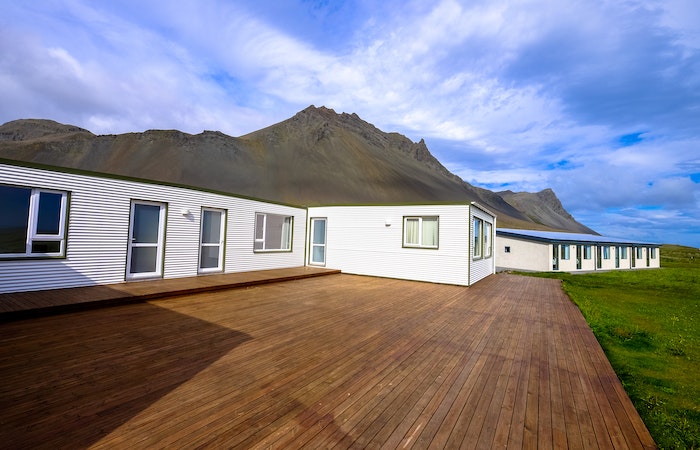 Mountain Across Houses on Green Grass Field Under Clear Blue Sky - how to install a deck