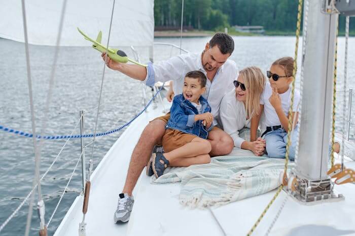 boating safety tips for kids featured image - mom and dad on a boat with their daughter and sun